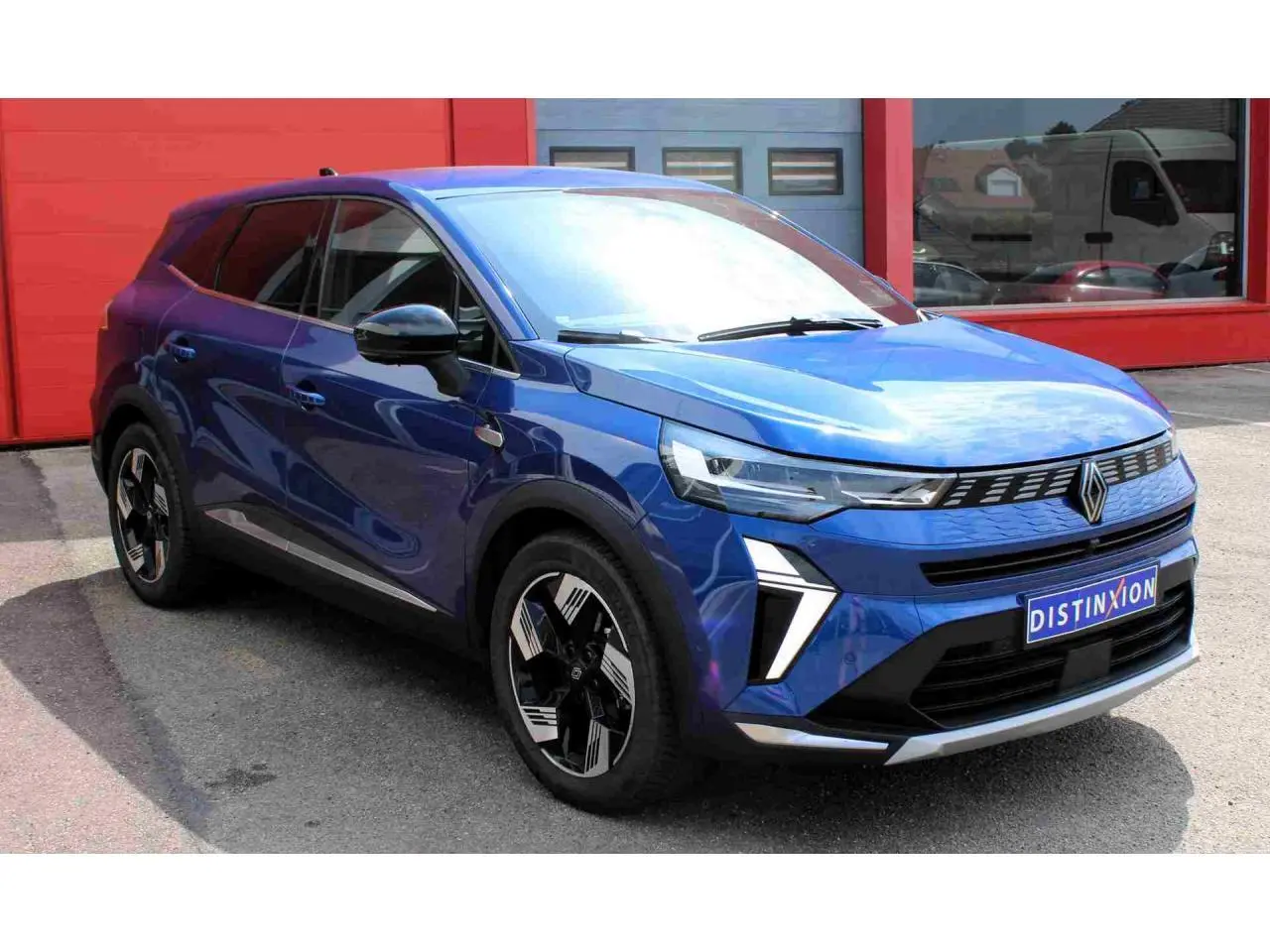 Renault Symbioz bleu Iron en 3/4 avant droit, avec calandre 3D et jantes alliage 19 pouces pulsar.
