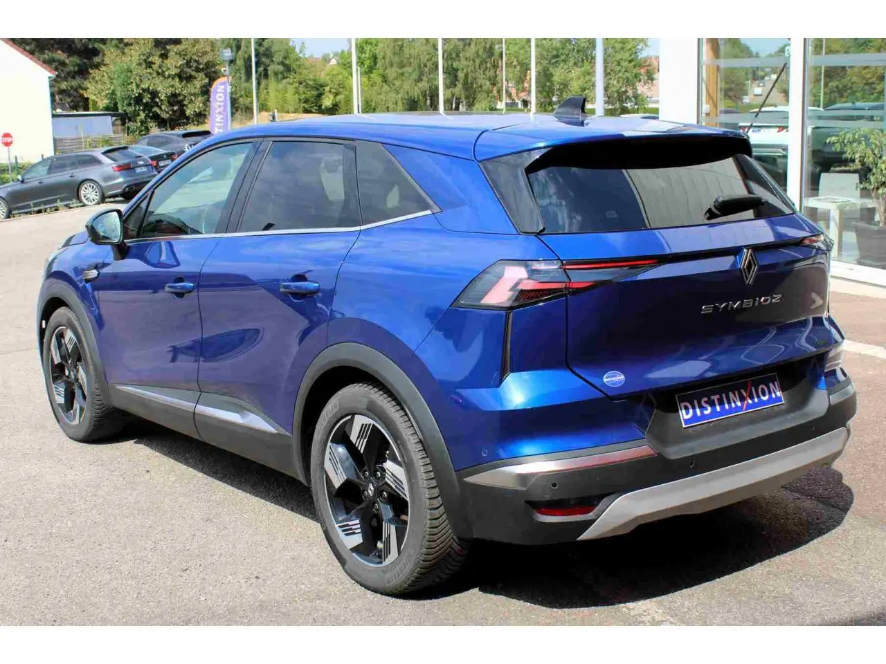 Vue 3/4 arrière droite du Renault SYMBIOZ bleu avec jantes alliage noires et vitres teintées.
