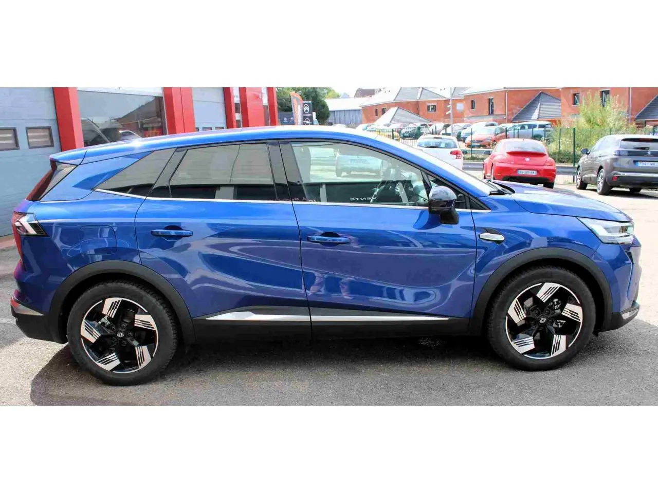 Profil droit du Renault Symbioz 2025 bleu Iron avec jantes alliage 19 pouces et montants noirs brillants.