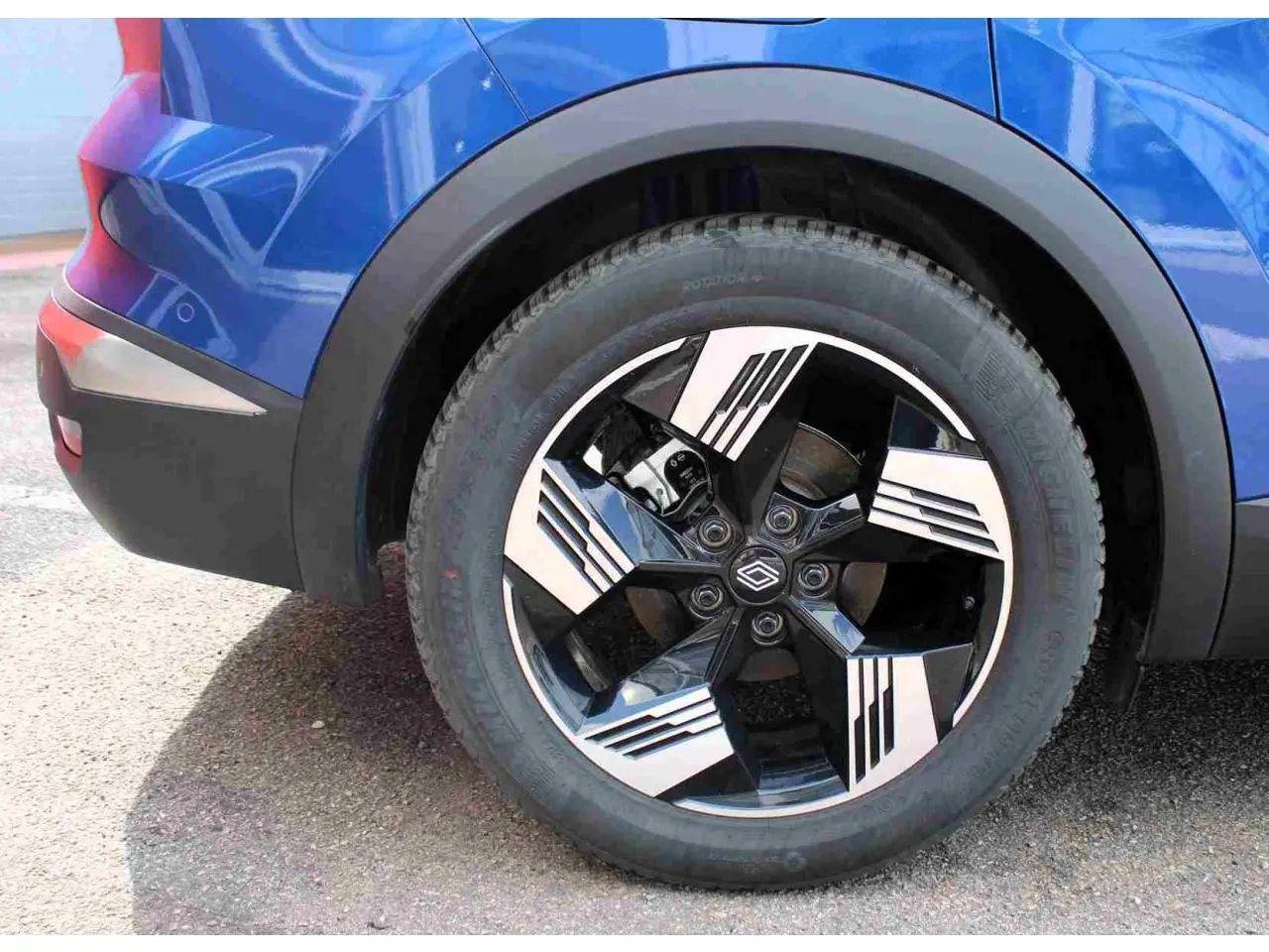 Gros plan sur la roue arrière droite du Renault Symbioz bleu avec jante alliage 19 pouces au design noir et argent.