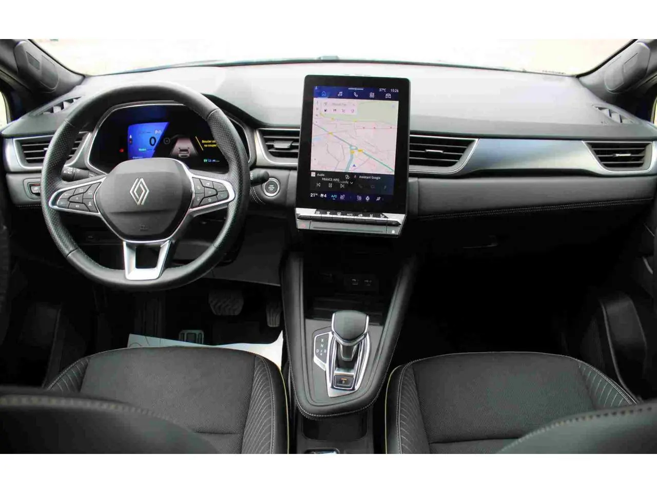 Vue intérieure avant du tableau de bord et volant de la Renault SYMBIOZ 2025 avec écran tactile vertical et levier de vitesse e-shifter.