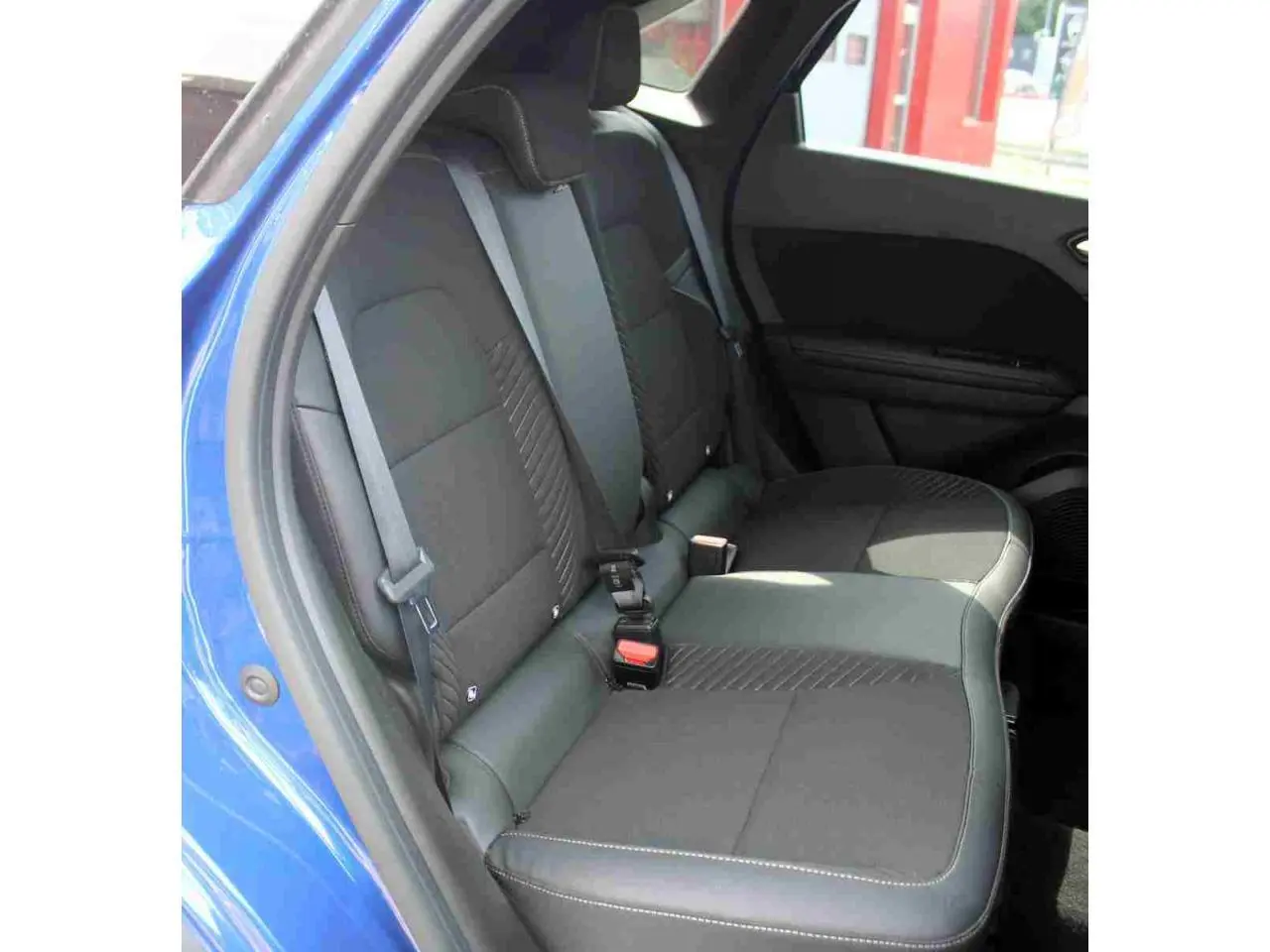 Vue intérieure côté gauche sur la banquette arrière noire du Renault Symbioz 2025 en bleu Iron.