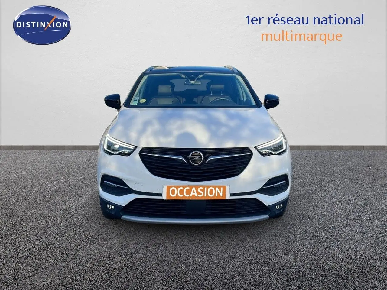 Opel Grandland X blanc toit noir en vue frontale, mettant en valeur sa calandre noire et ses phares LED distinctifs.
