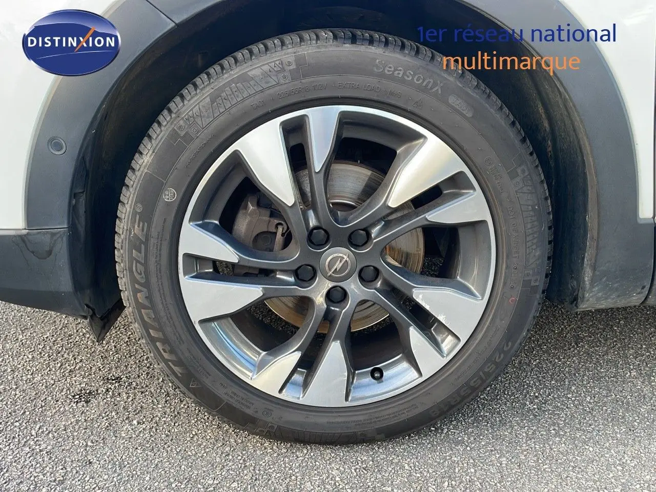 Gros plan sur la jante alliage grise du côté avant droit d'un Opel Grandland X blanc toit noir.