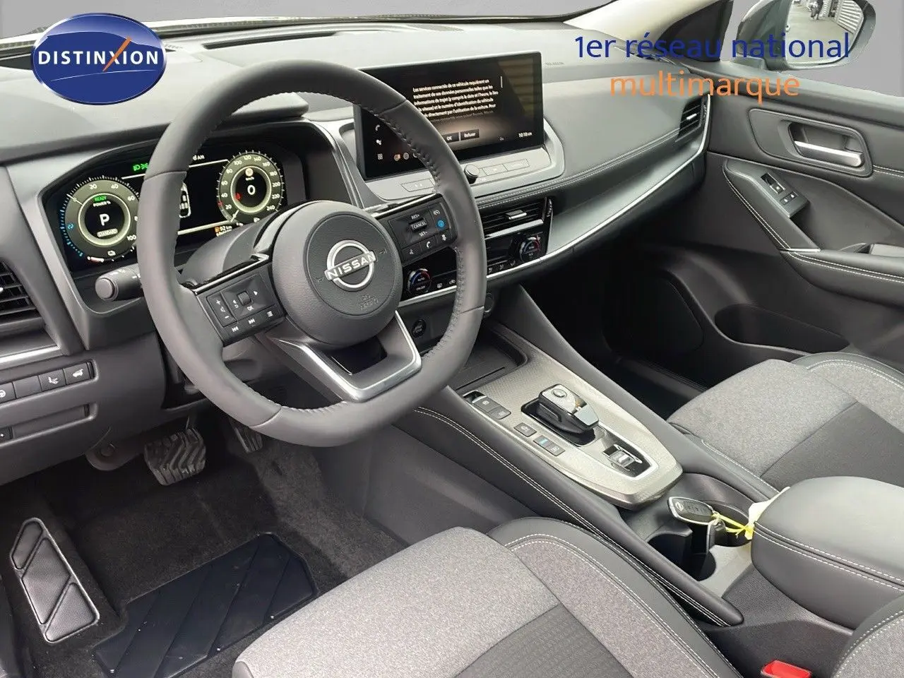 Vue intérieure côté conducteur du Nissan Qashqai 2025, tableau de bord moderne avec écran tactile et volant cuir noir.