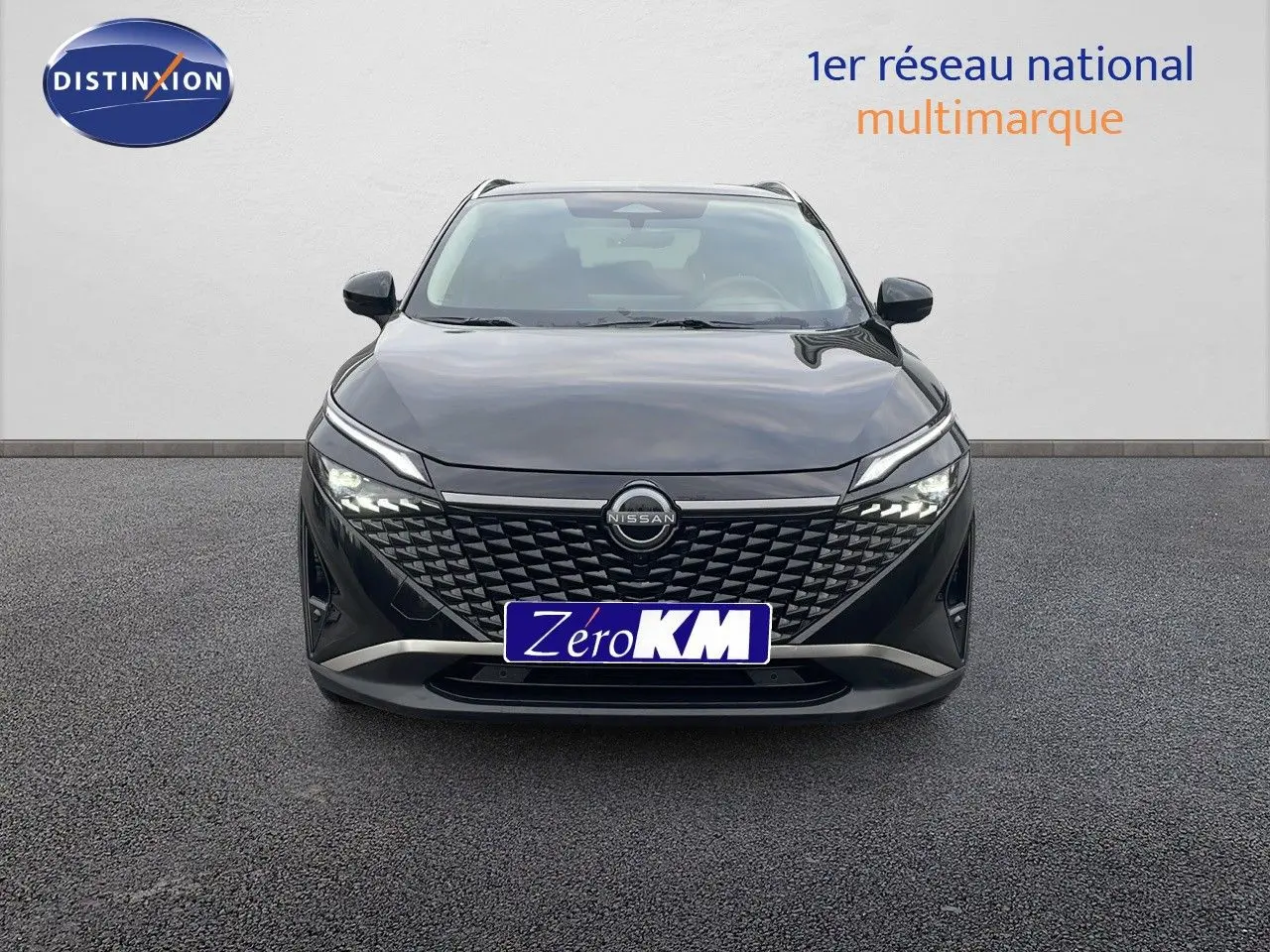 Vue frontale d'un Nissan Qashqai noir perle métal avec calandre à motifs géométriques et phares LED allumés.