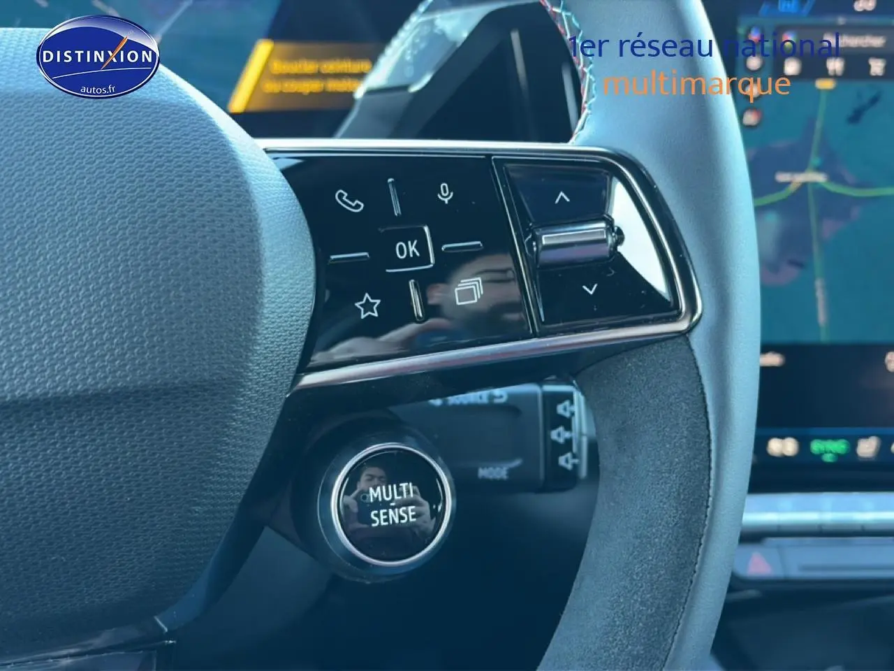 Gros plan sur le volant noir avec commandes multifonctions et bouton Multi-Sense du Renault Austral bleu outremer 2025.