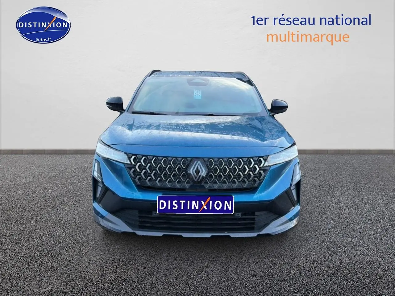 Vue frontale d'un Renault Austral bleu outremer avec calandre distinctive et logo Renault centré.
