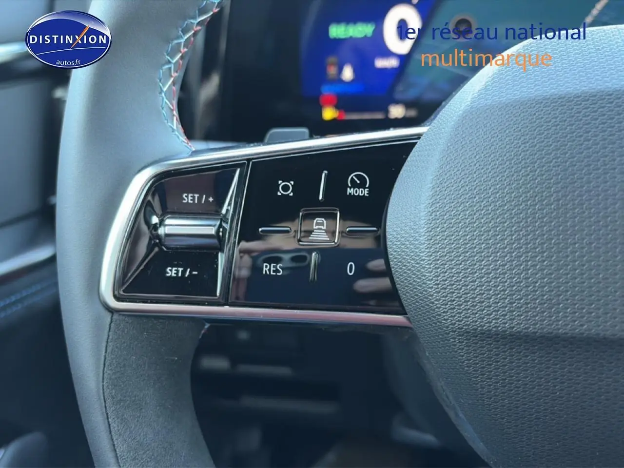 Gros plan sur les commandes au volant du Renault Austral 2025, finition Esprit Alpine, avec surpiqûres bleues visibles.