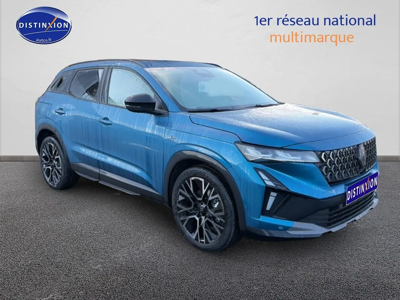 Renault Austral 2025 bleu outremer en 3/4 avant droit avec jantes alu et calandre noire distinctive.