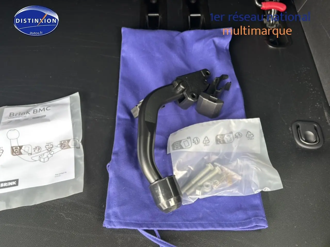 Gros plan sur un attelage col de cygne noir posé sur un tissu bleu dans le coffre d’un FIAT Scudo Combi noir.