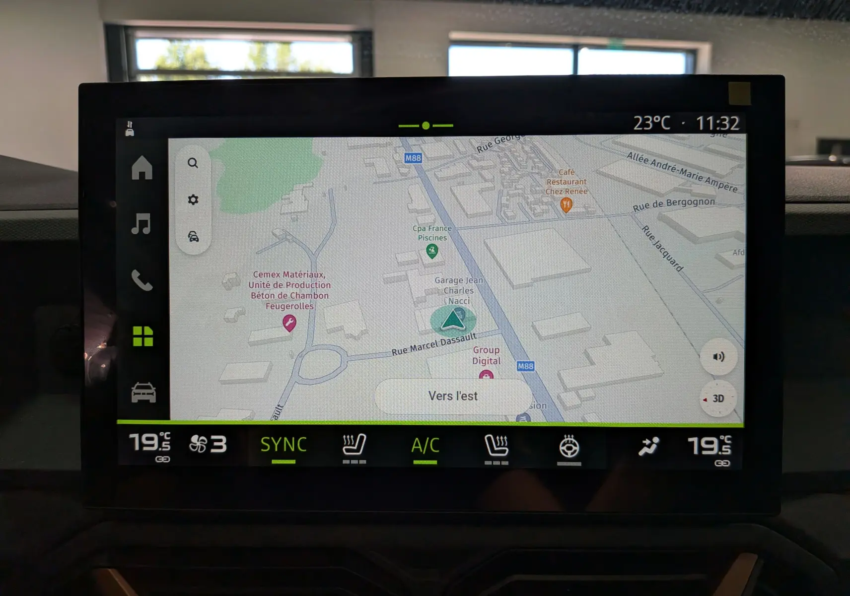 Écran tactile intérieur du Dacia Bigster Hybrid-G 150 4x4 montrant la navigation avec carte et commandes climatisation.
