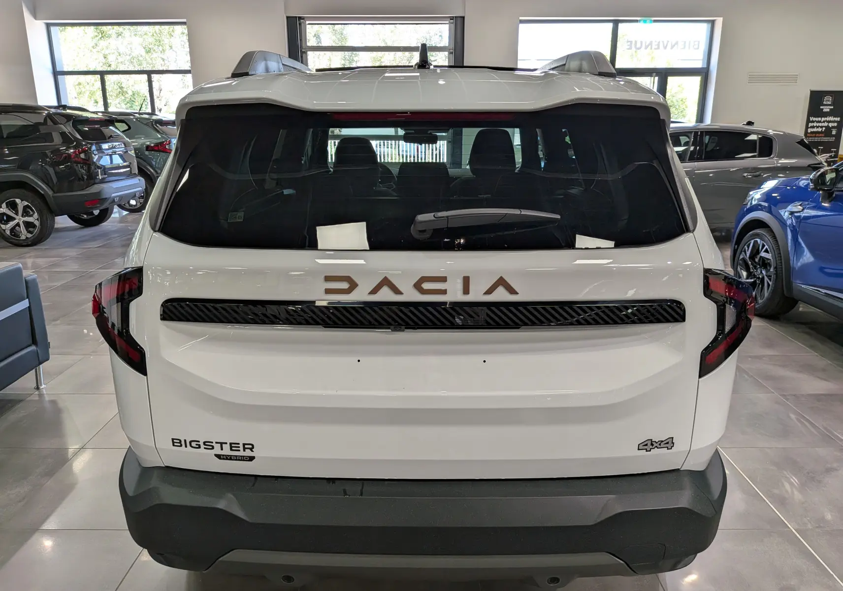 Vue arrière d’un Dacia Bigster blanc Glacier Hybrid-G 150 4x4, avec logo DACIA en relief et badges distinctifs visibles.