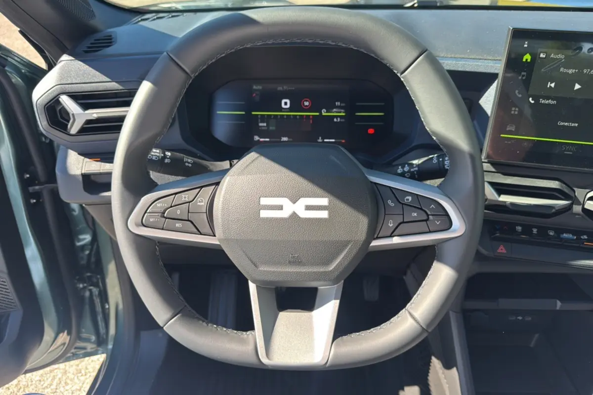 Vue rapprochée du volant cuir noir et du tableau de bord numérique du Dacia Bigster 2025 vert cèdre.