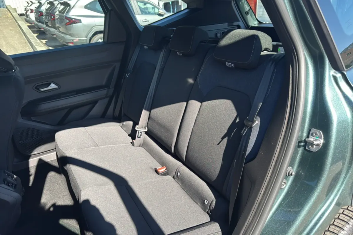 Vue intérieure côté droit sur la banquette arrière noire du Dacia Bigster vert cèdre avec porte ouverte.