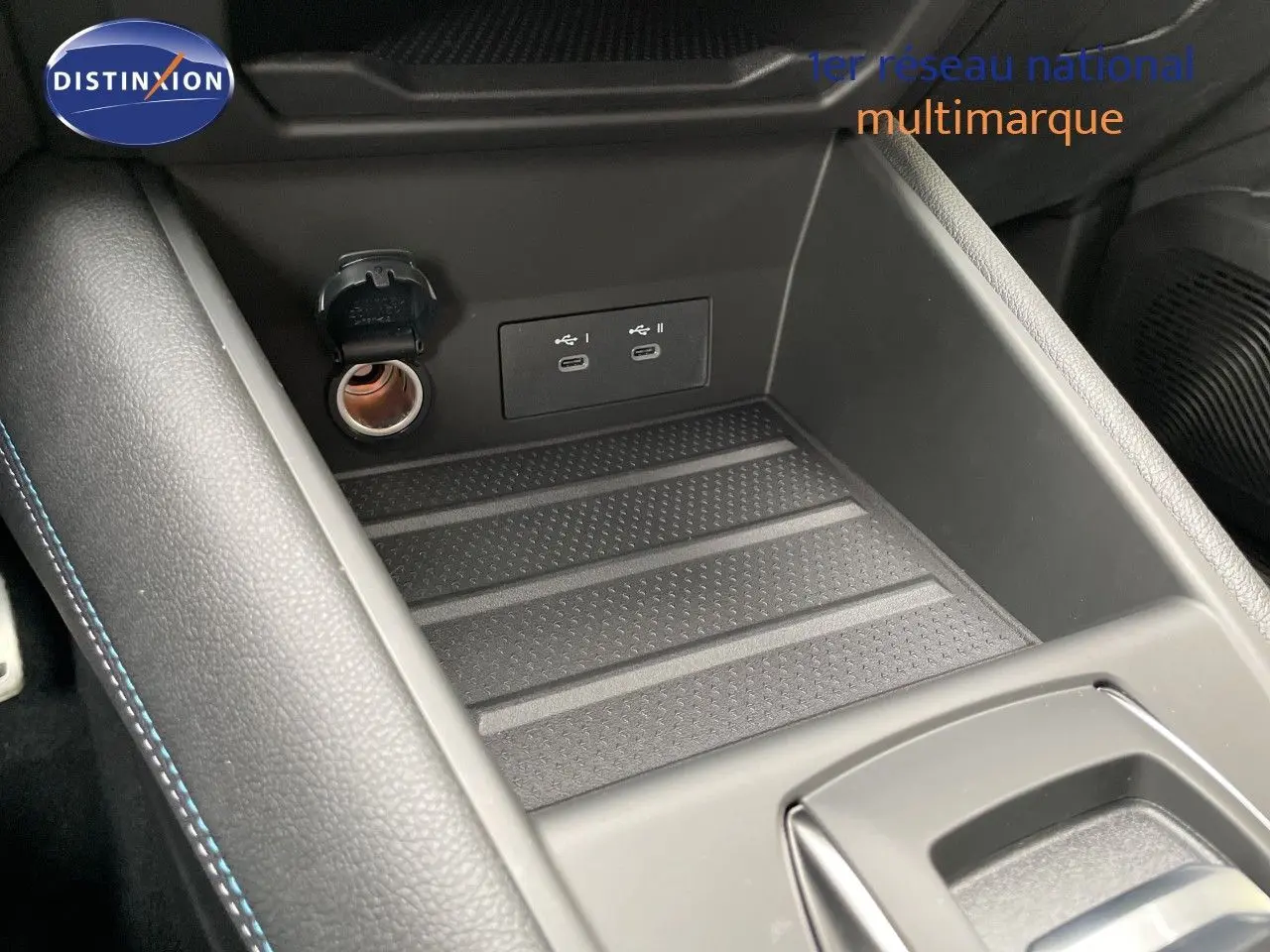 Gros plan sur la console centrale avec prise 12V et deux ports USB-C dans une Renault Symbioz gris Rafale métal.