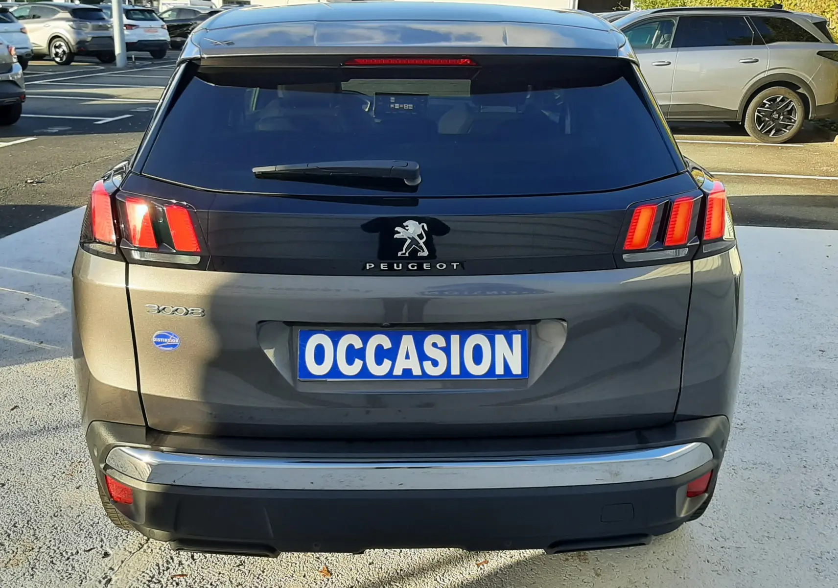 Vue arrière d'un Peugeot 3008 gris platinium 2023 avec feux LED caractéristiques et plaque "OCCASION".