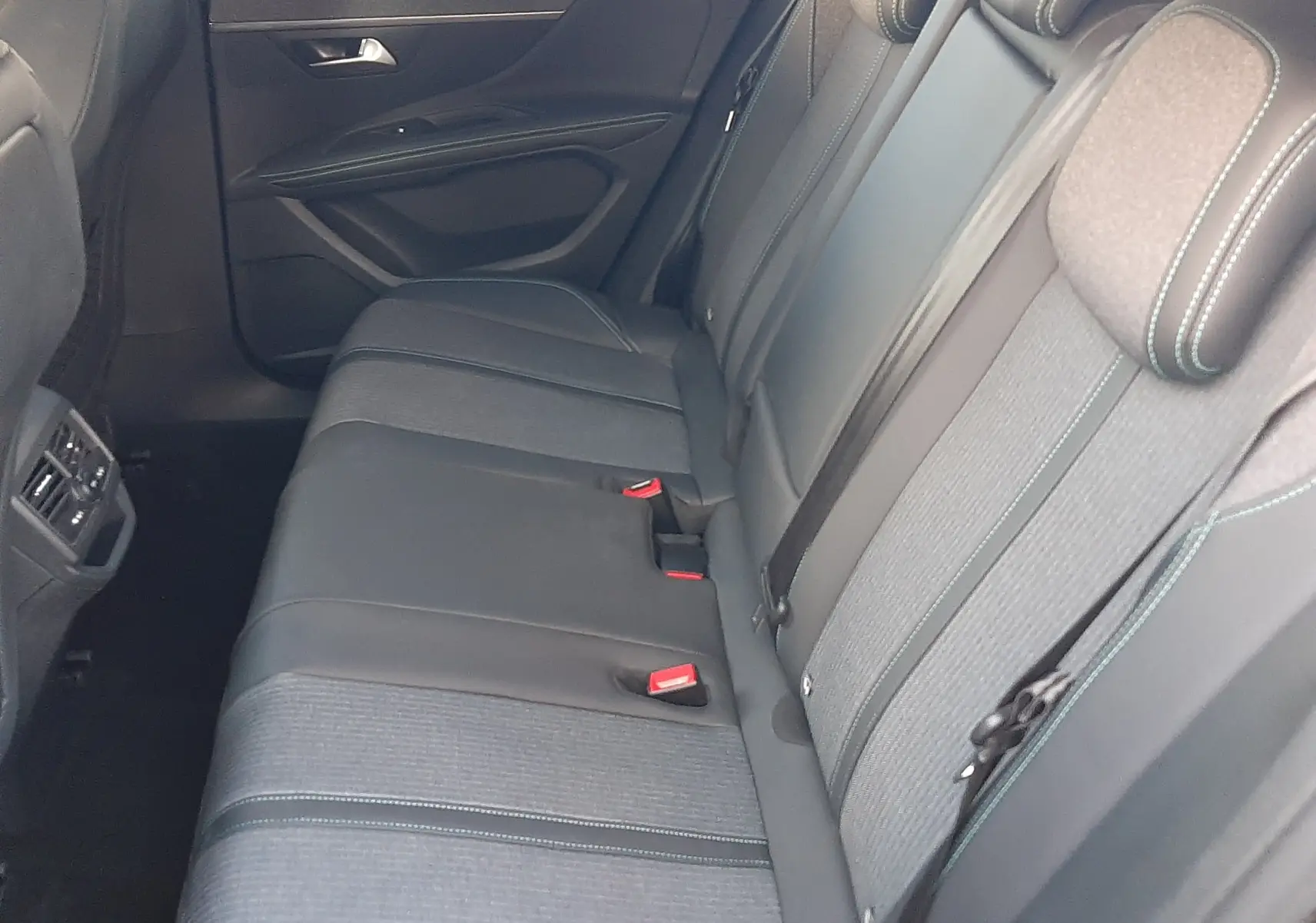 Vue intérieure côté droit des sièges arrière gris foncé avec surpiqûres vertes du Peugeot 3008 2023.