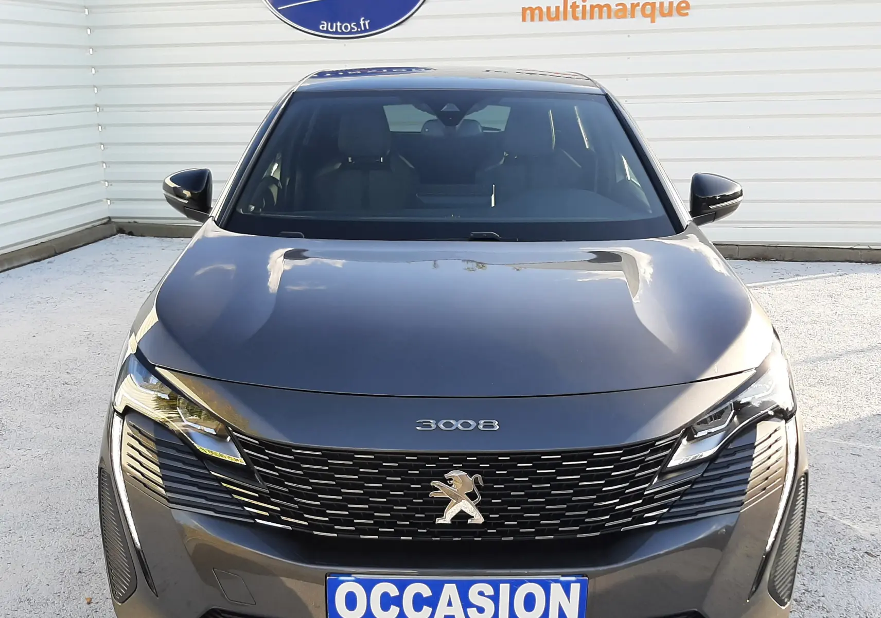 Vue frontale d'un Peugeot 3008 gris platinium 2023 avec calandre noire et logo lion distinctif.