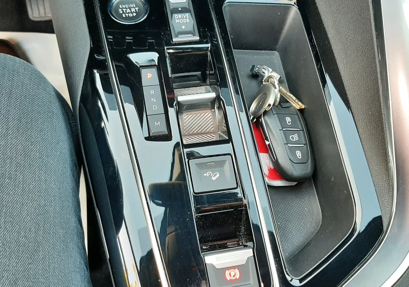 Vue rapprochée de la console centrale noire brillante du Peugeot 3008 2023 avec clés et sélecteur de boîte automatique.