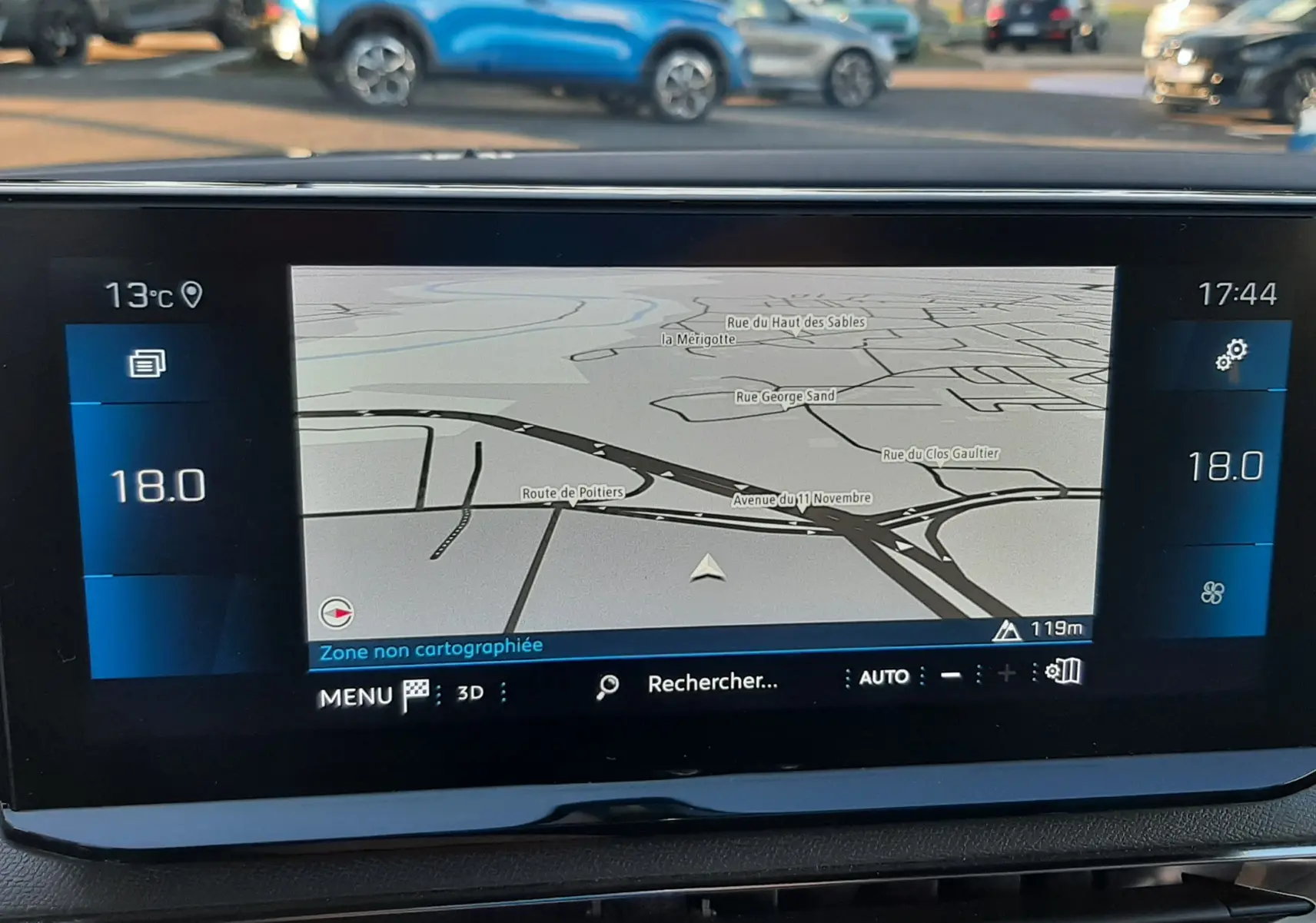 Écran central du tableau de bord du Peugeot 3008 gris platinium 2023 affichant la navigation GPS et la température intérieure à 18°C.
