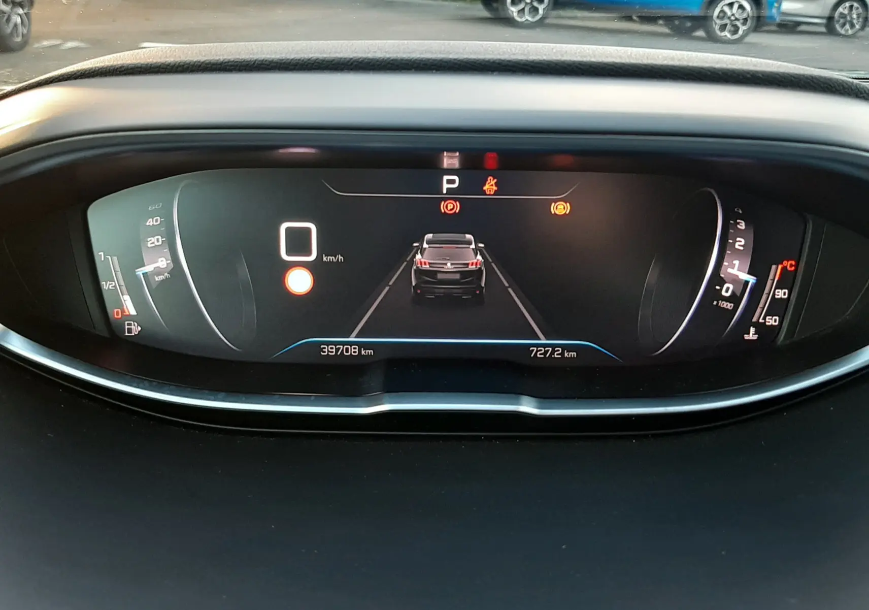 Vue du tableau de bord numérique du Peugeot 3008 gris platinium 2023, affichant la vitesse à 0 km/h et l'alerte de stationnement.