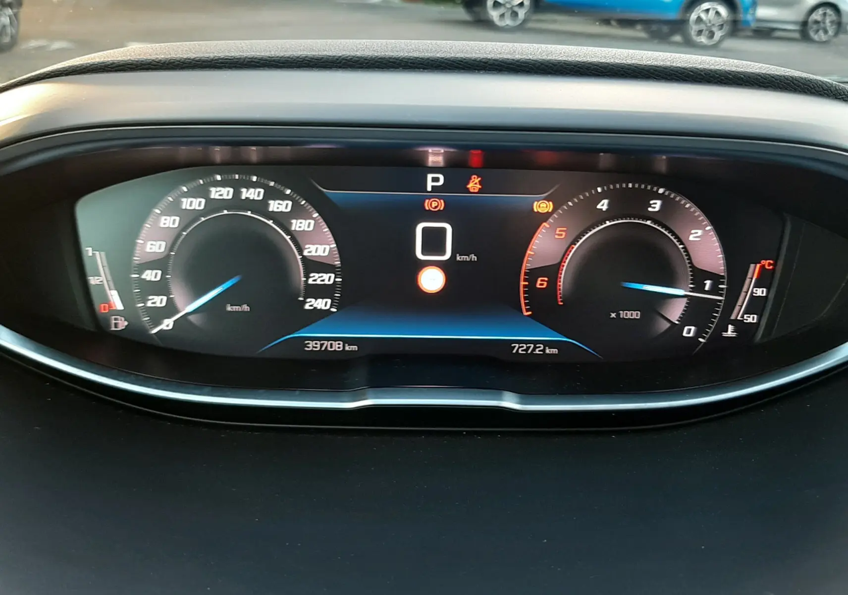 Tableau de bord numérique du Peugeot 3008 2023, affichant vitesse à 0 km/h et compteurs modernes en vue frontale.