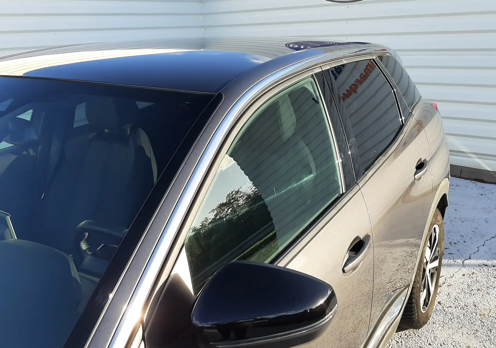 Vue 3/4 avant droit du Peugeot 3008 gris platinium 2023 avec toit noir et rétroviseur noir brillant.
