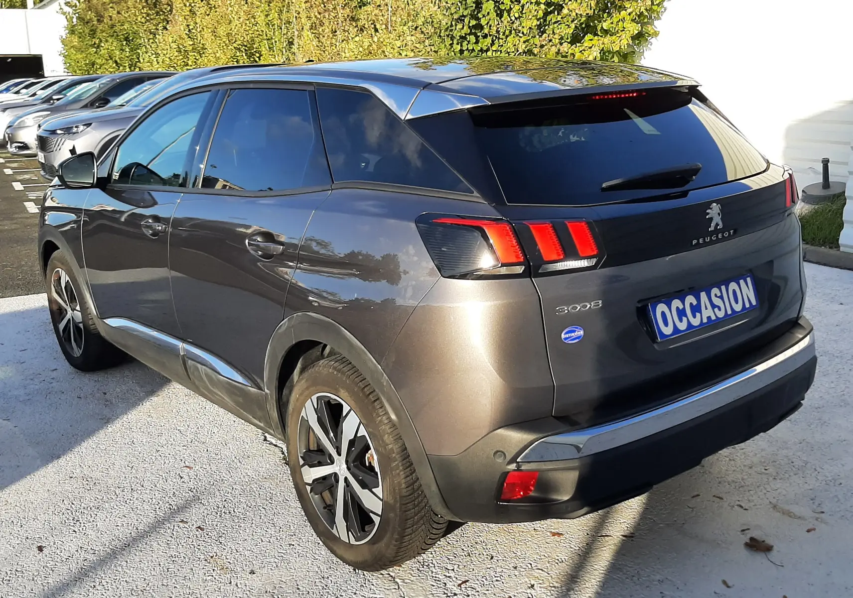 Vue 3/4 arrière droite d’un Peugeot 3008 gris platinium 2023 avec feux arrière à LED et jantes alliage bicolores.