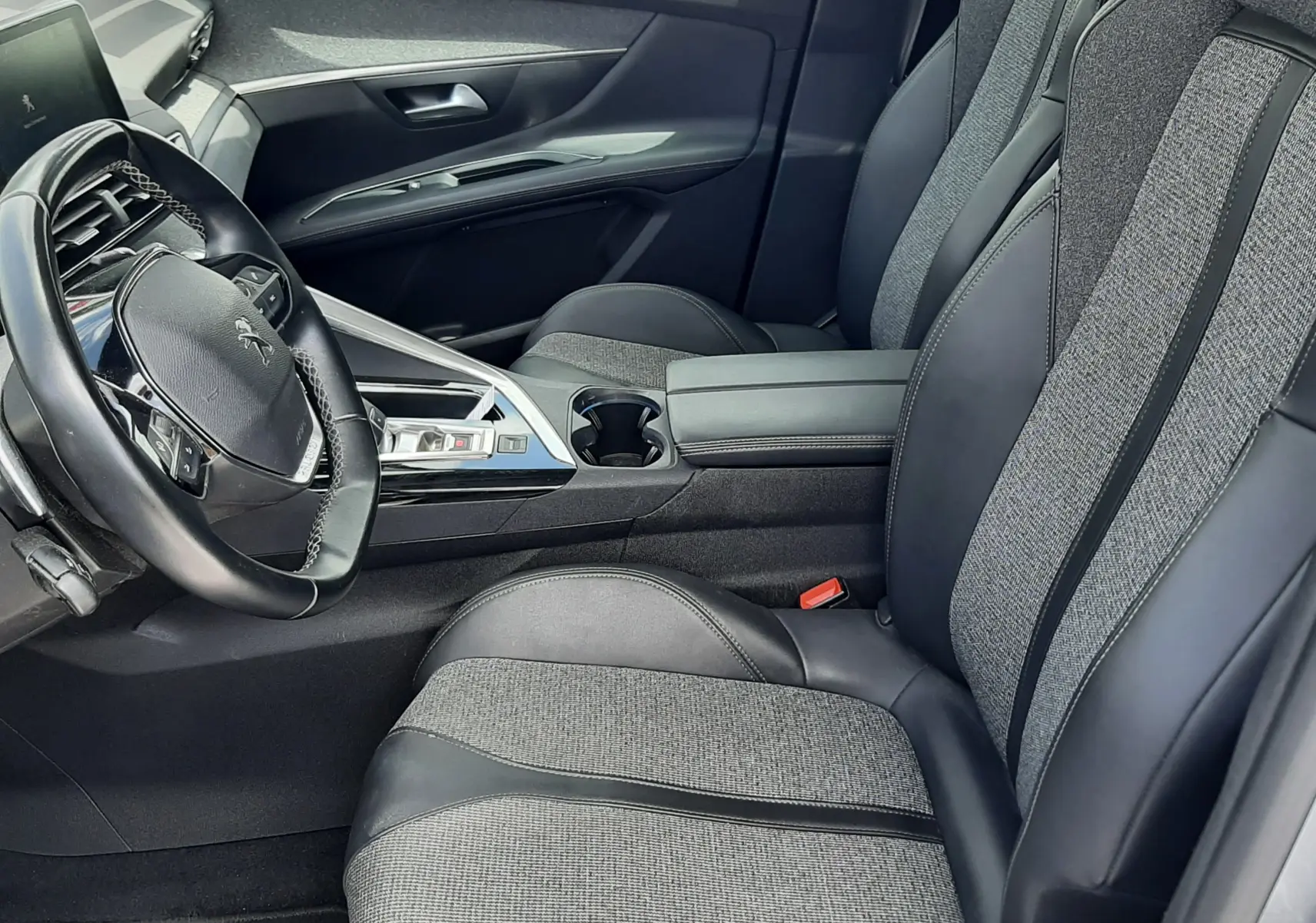 Vue intérieure côté conducteur du Peugeot 3008 2020, sièges gris tissu et cuir avec console centrale moderne.