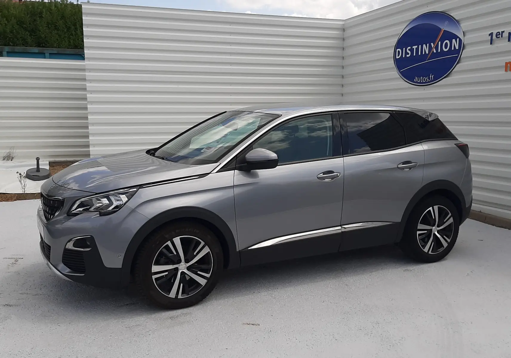 Peugeot 3008 gris vue de profil côté gauche, avec jantes alliage bicolores et vitres teintées.