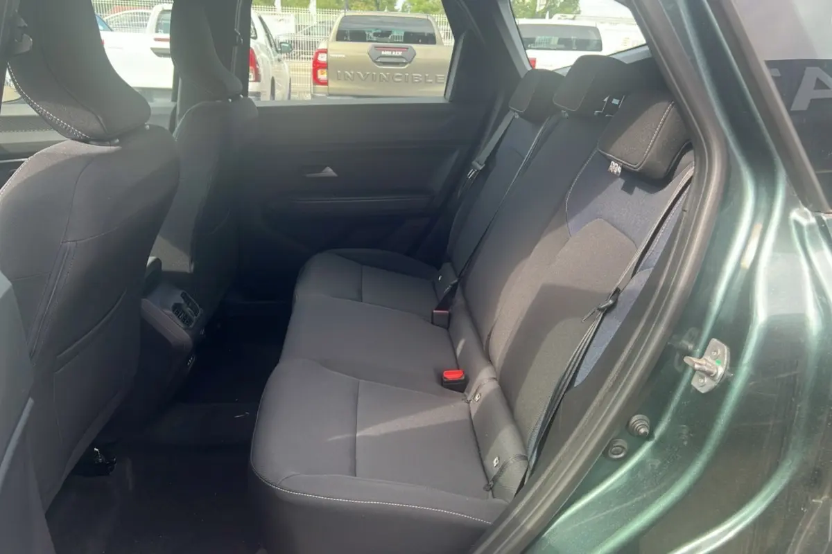 Vue intérieure montrant la banquette arrière du Dacia Bigster 2025 vert cèdre avec portes ouvertes côté droit.