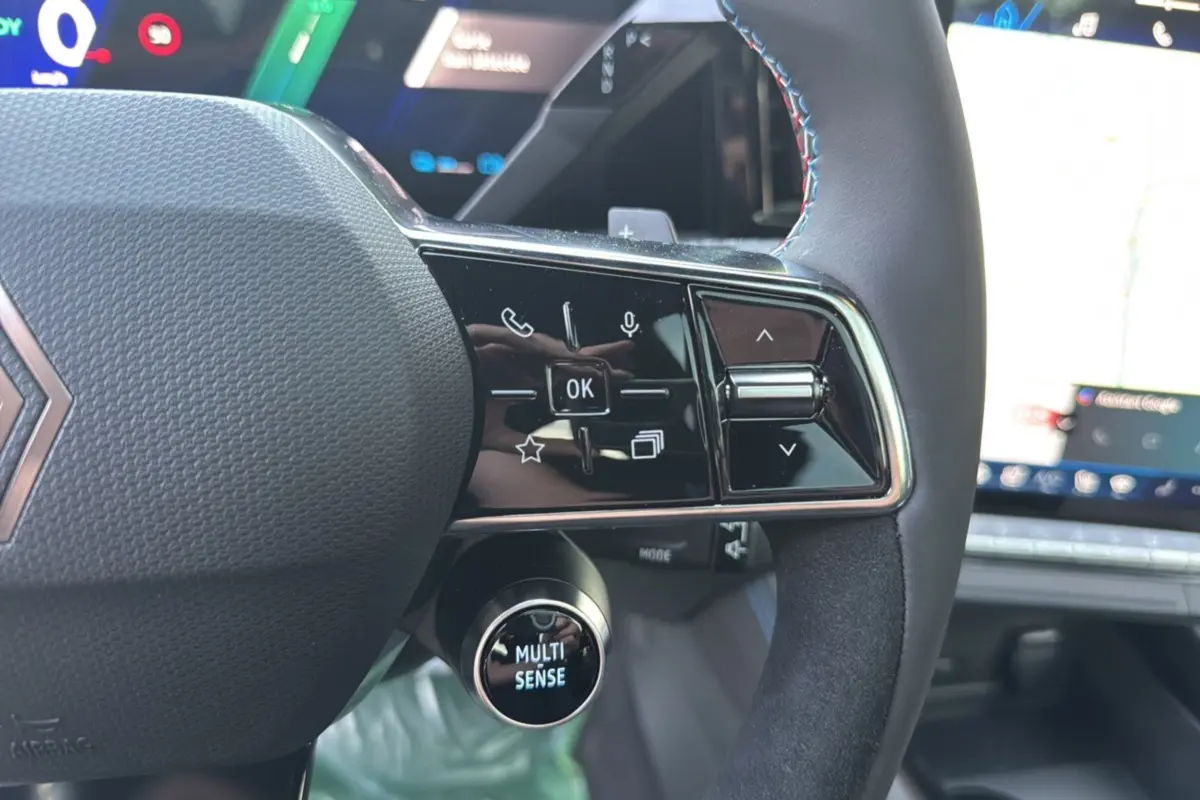 Gros plan sur le volant du Renault Austral New 200 Esprit Alpine, noir étoilé, avec commandes multifonctions et bouton Multi-Sense.