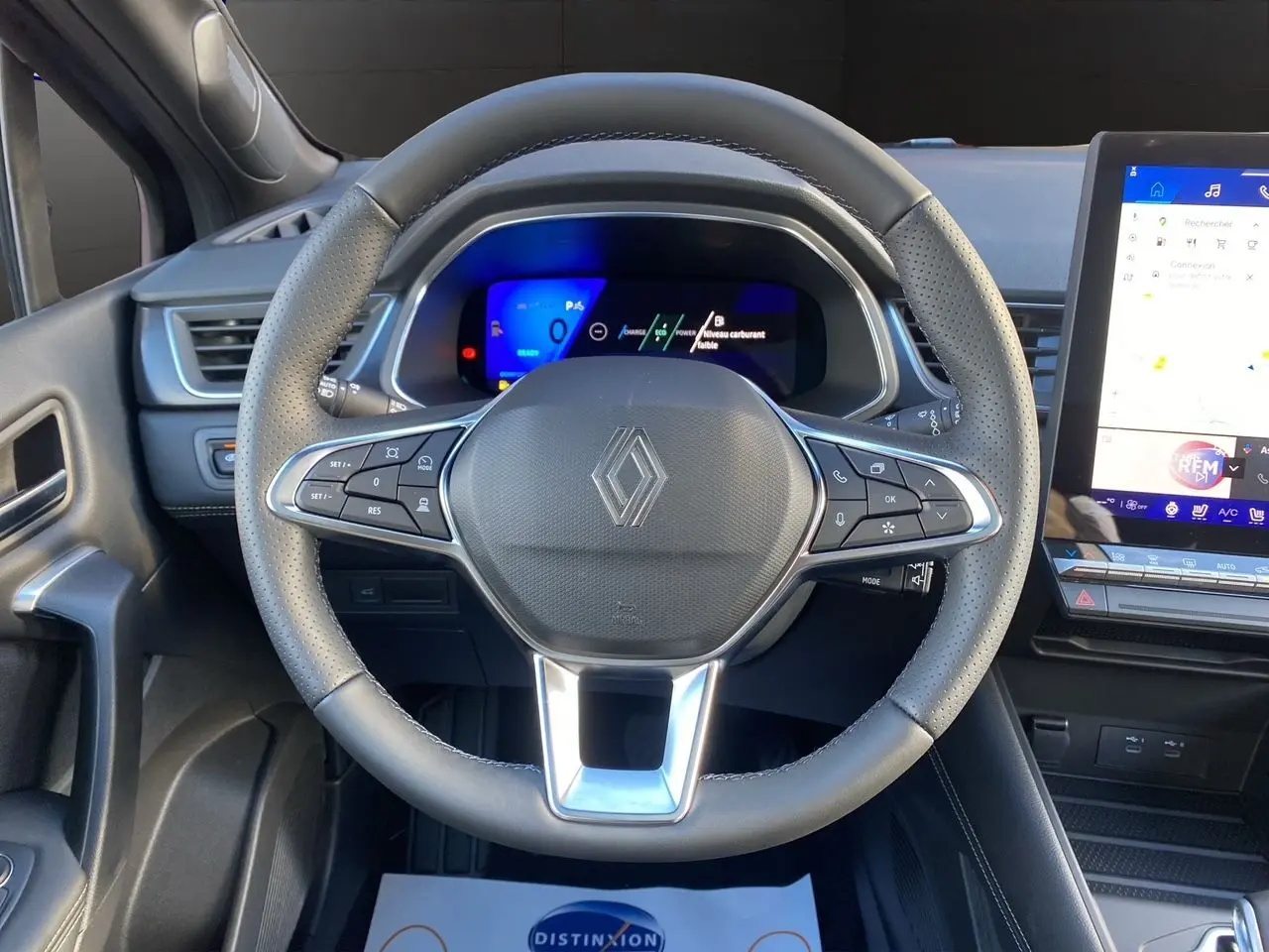 Vue rapprochée du volant noir perforé et du tableau de bord numérique du Renault Symbioz Iconic E-Tech Hybrid 2025.