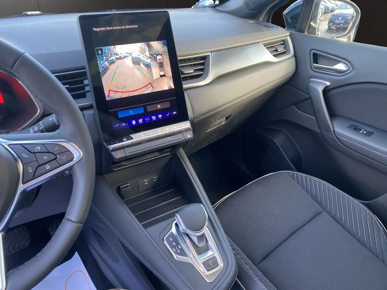 Intérieur avant droit de la Renault SYMBIOZ noir étoile 2025, avec écran tactile affichant la caméra de recul et boîte auto.