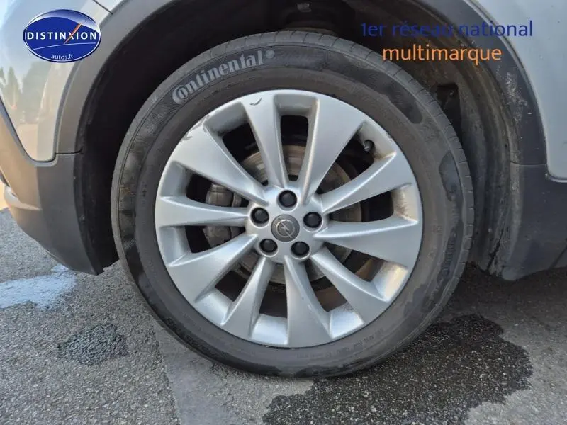 Gros plan sur la roue avant gauche d’un Opel Mokka gris Astéroïde avec jante alu et pneu Continental.