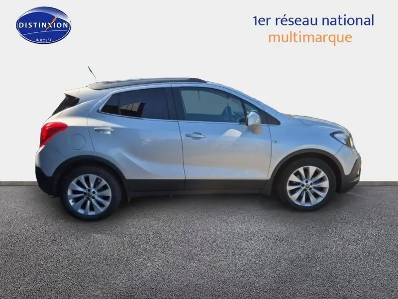 Opel Mokka gris astéroïde vu de profil côté gauche, avec jantes alliage et vitres teintées.