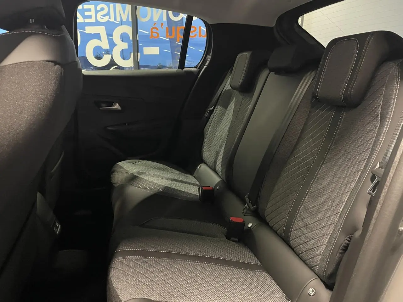 Vue intérieure côté droit des sièges arrière gris tissu et TEP avec surpiqûres Quartz du Peugeot 208 1.2i Hybrid 2025.