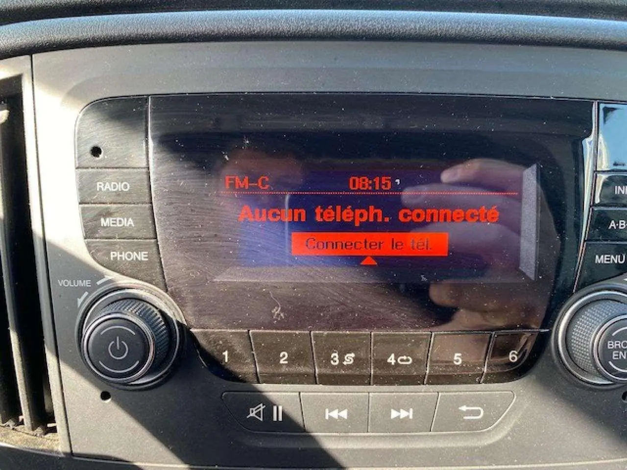 Gros plan sur l’autoradio du Fiat Doblo 2017 affichant l’écran rouge indiquant "Aucun téléph. connecté".