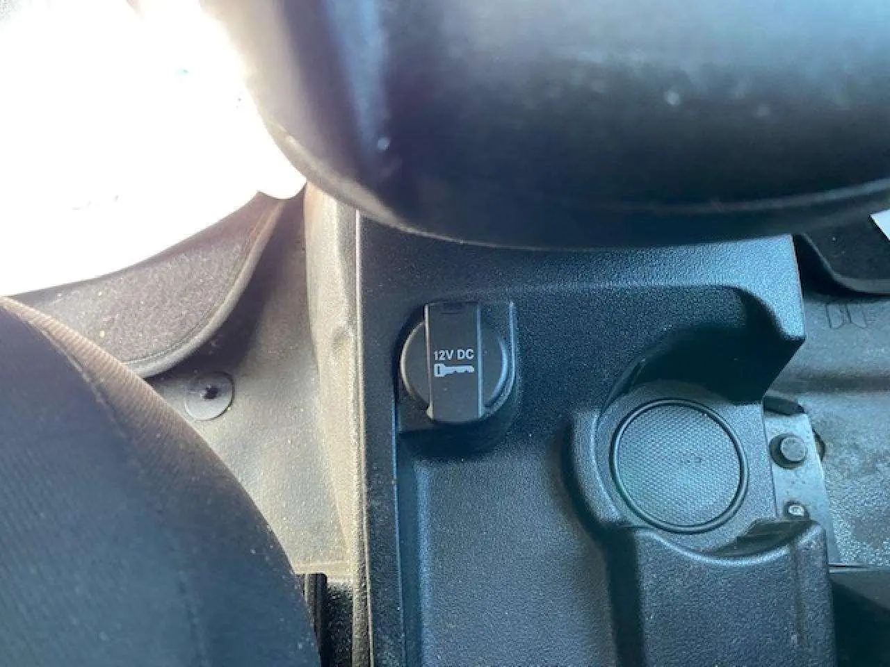 Vue rapprochée de la prise 12V et porte-gobelet dans l'habitacle du Fiat Doblo blanc de 2017.