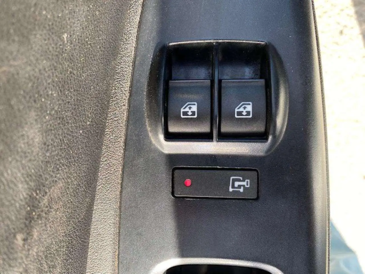 Gros plan sur les commandes de lève-vitres électriques côté conducteur du Fiat Doblo blanc de 2017.