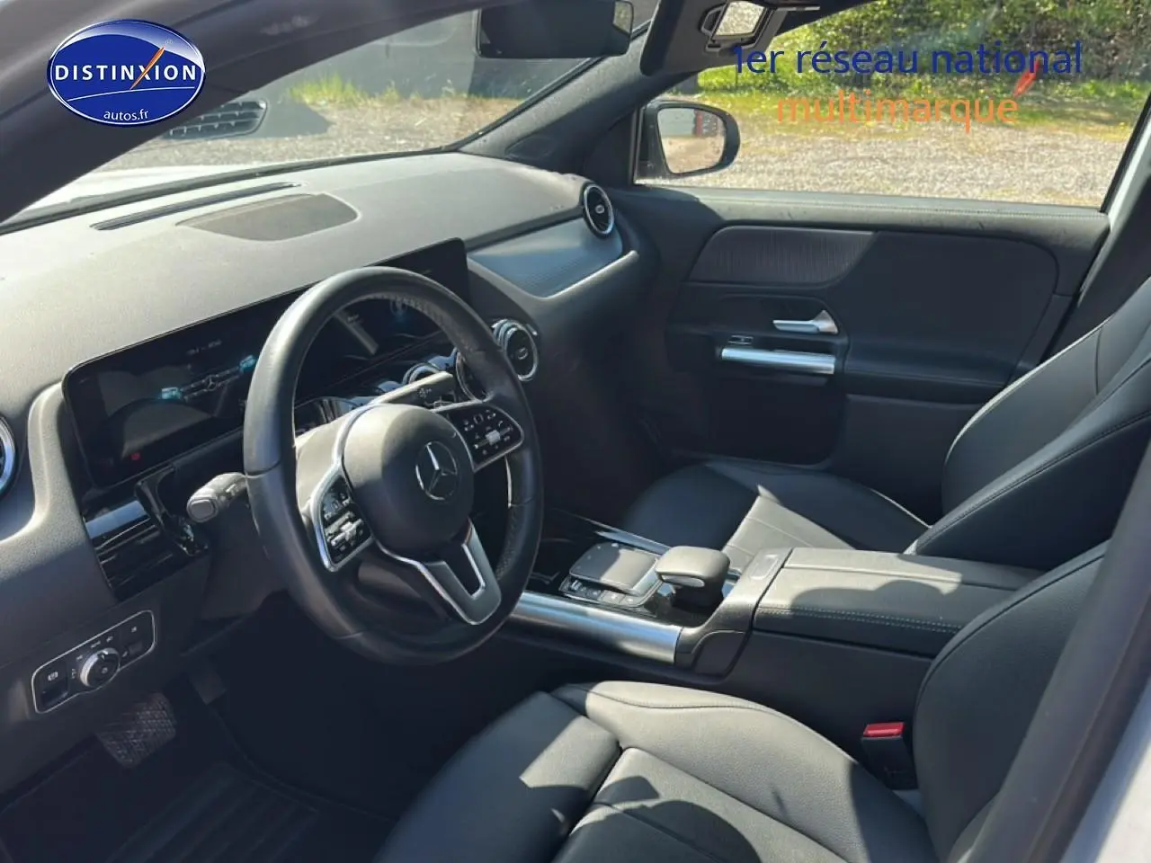 Intérieur noir de la Mercedes GLA 200 2022 vu côté conducteur, avec volant cuir multifonction et console centrale moderne.