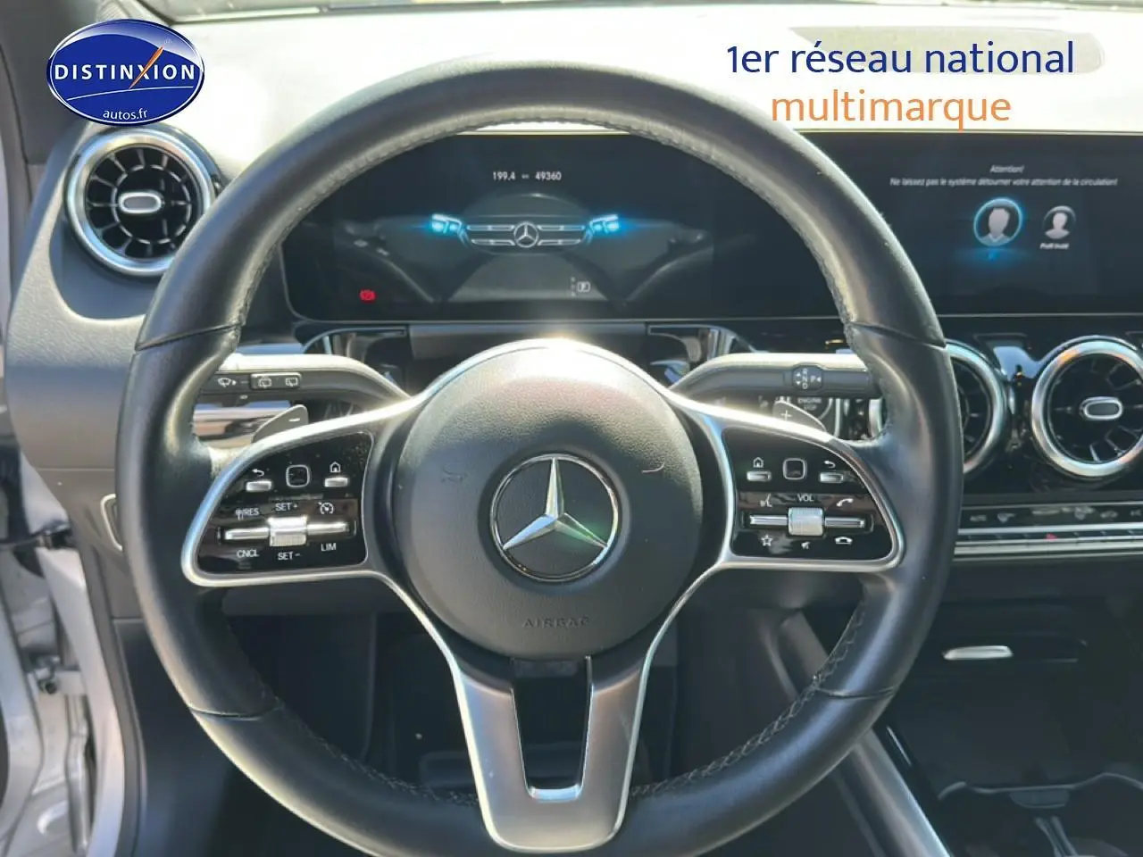 Vue rapprochée du volant cuir multifonction noir de la Mercedes GLA 200 2022 avec tableau de bord numérique.
