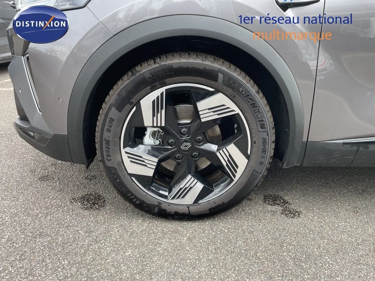 Gros plan sur la roue avant gauche d'une Renault Symbioz gris cassiopée métal, mettant en valeur la jante stylisée bicolore.