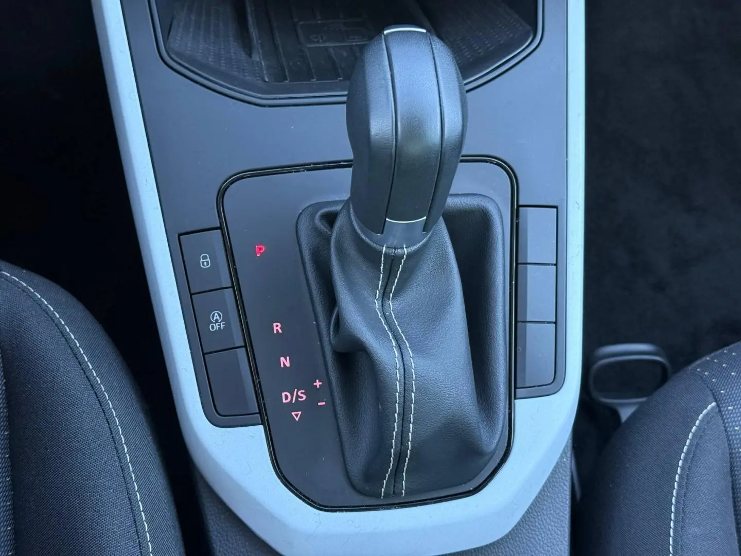 Gros plan sur le levier de vitesse automatique en cuir noir avec surpiqûres blanches dans une SEAT Arona 2025.