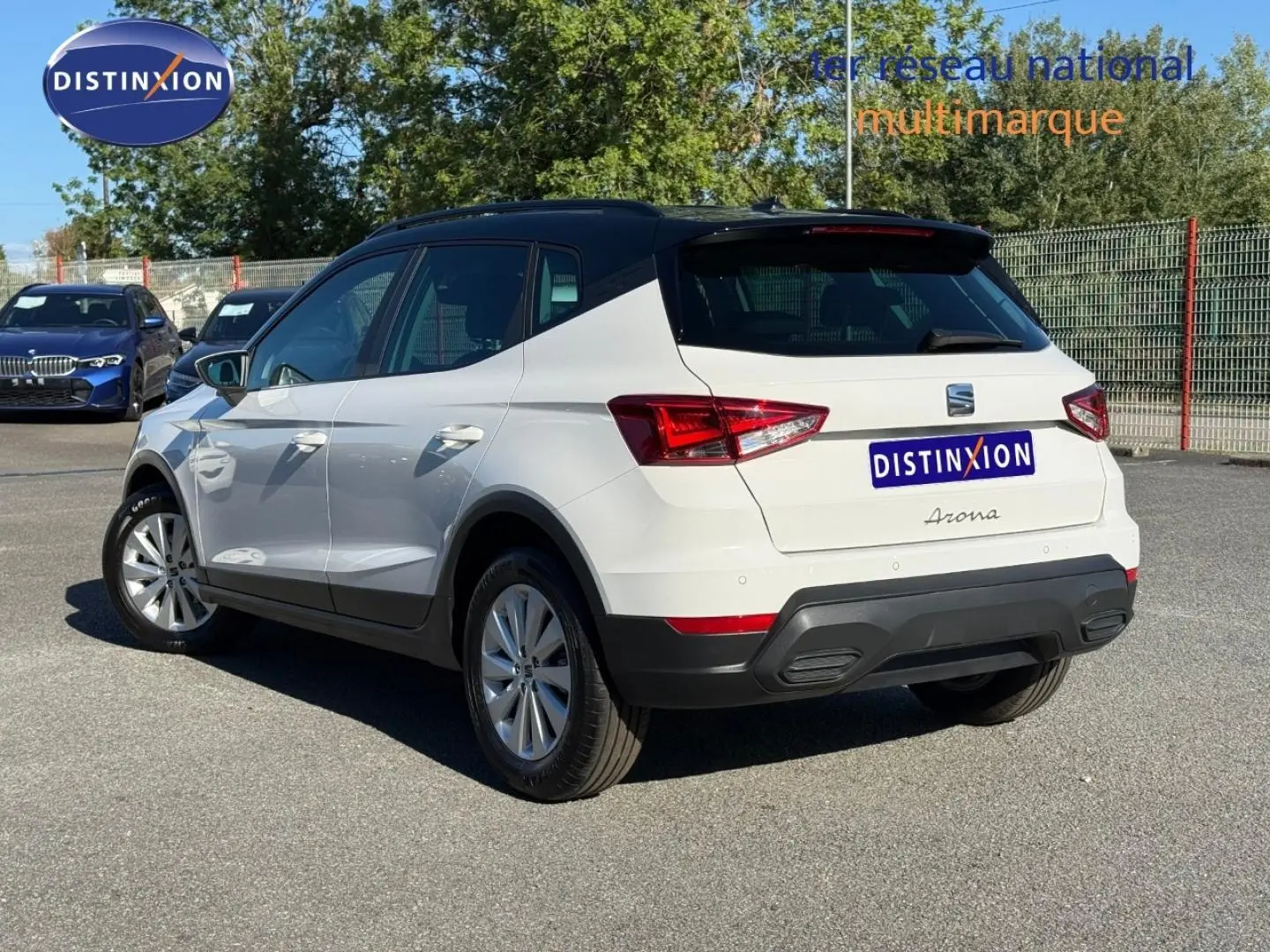 Vue 3/4 arrière droite d'un SEAT Arona blanc Candy avec toit noir Minuit, jantes alu et feux arrière LED.