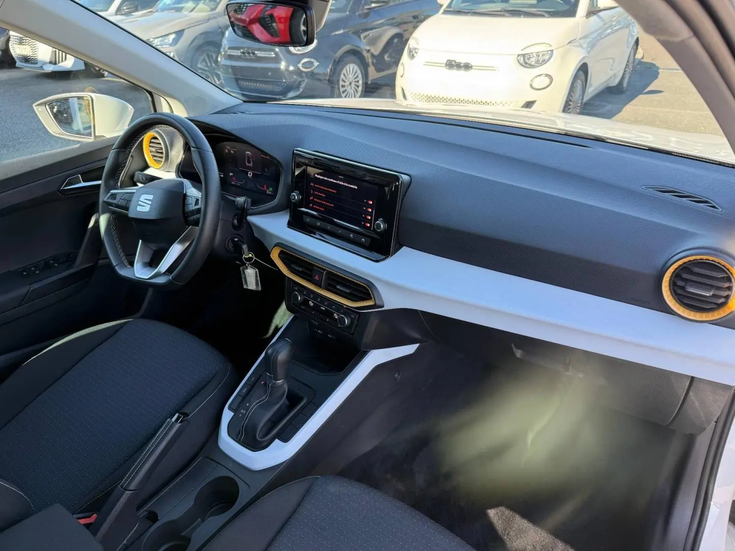 Intérieur avant droit du SEAT Arona blanc, volant cuir multifonction et tableau de bord avec écran tactile.