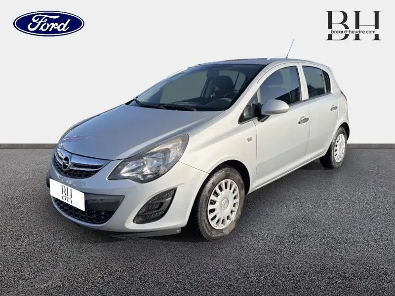 Opel Corsa gris minéral vue 3/4 avant droit, mettant en valeur sa calandre chromée et ses phares halogènes.