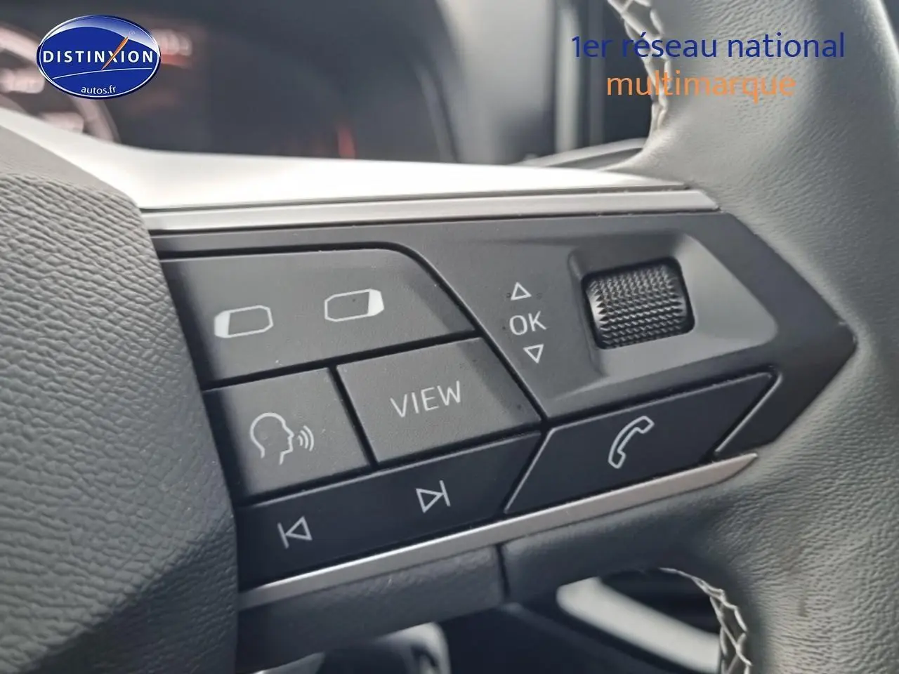 Gros plan sur les commandes multifonctions noires du volant cuir du SEAT Arona gris magnétique 2025.