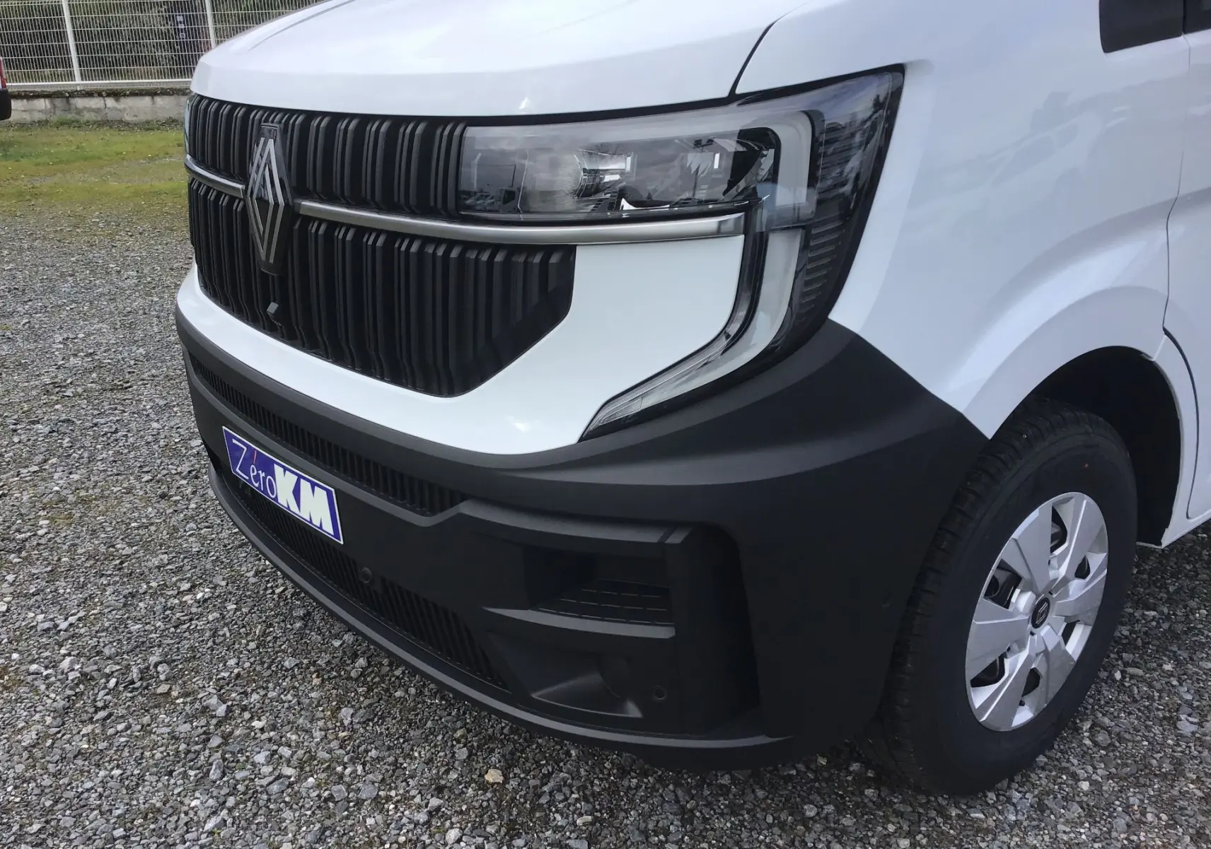 Gros plan sur l’avant droit du Renault Master blanc 2025, mettant en valeur la calandre noire et le phare moderne.